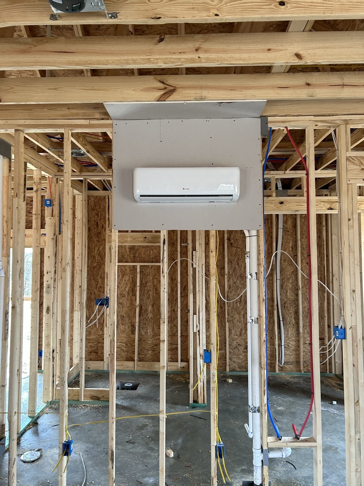 Mini-split HVAC head installed during framed residential construction.
