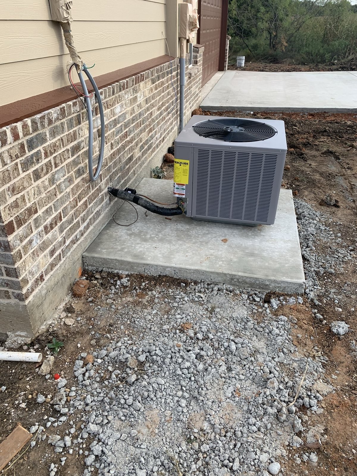 Outdoor HVAC condenser installed beside a residential exterior wall.