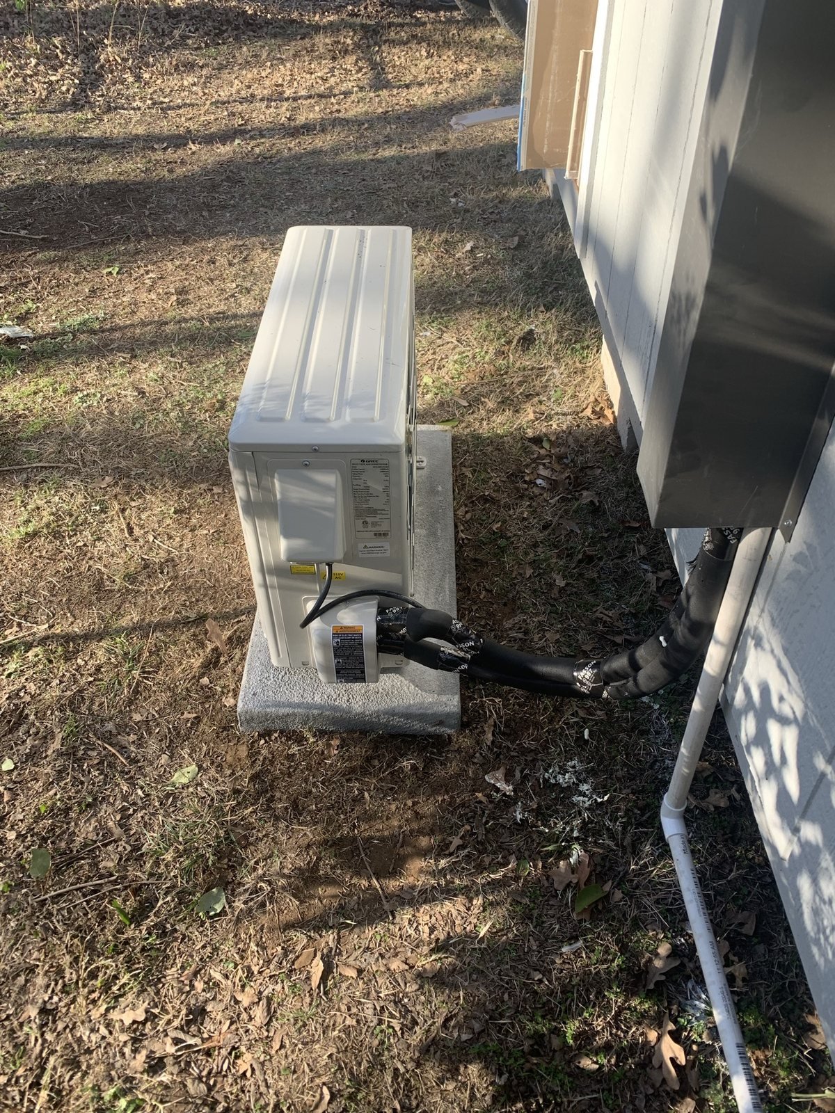 Exterior mini-split HVAC condenser with line set routed along the wall.