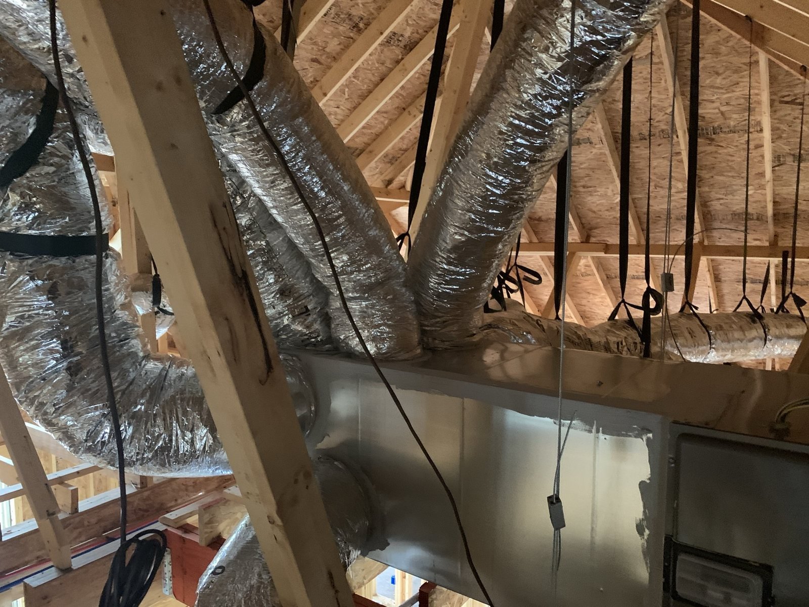 HVAC ductwork and air handler equipment installed in an attic.